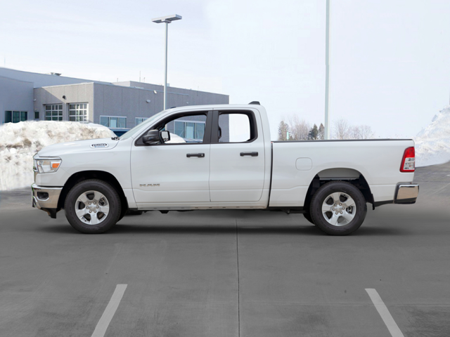 A white 2024 RAM 1500 parked in a clear parking lot with some snow piled in the background near Pleasanton, TX
